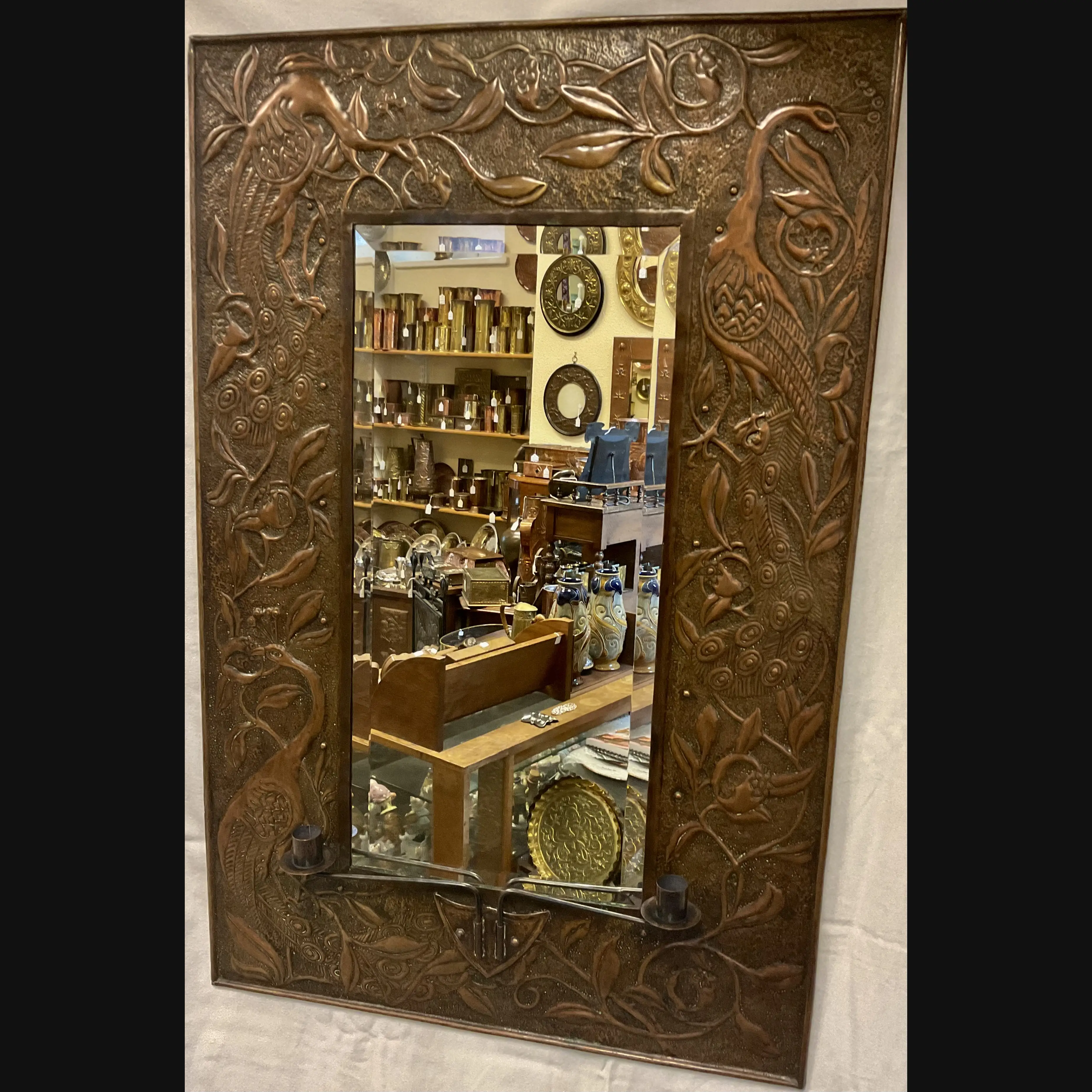 large arts and crafts copper mirror with candle sconces worked with peacocks and pomegranates c1900 10