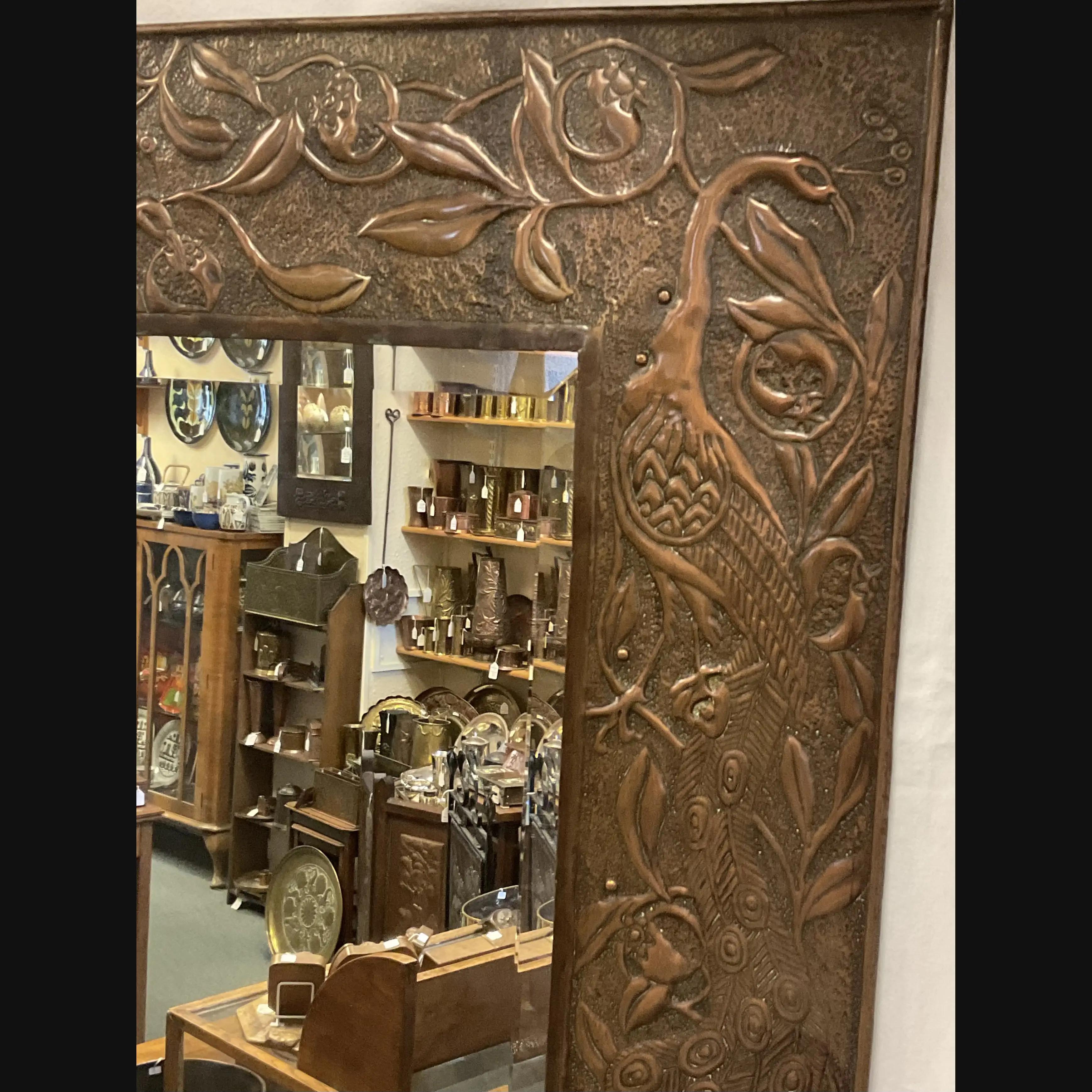 large arts and crafts copper mirror with candle sconces worked with peacocks and pomegranates c1900 10