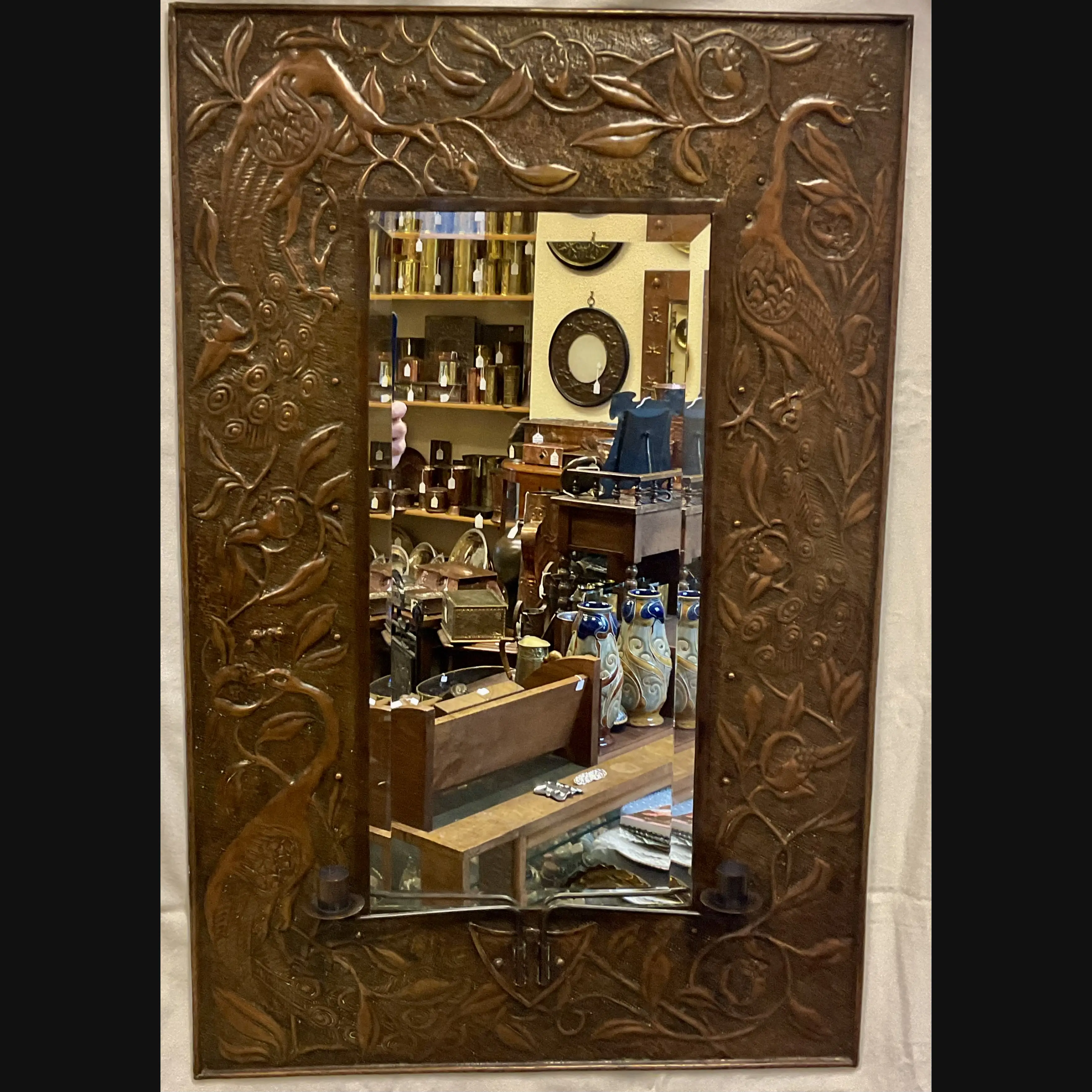 large arts and crafts copper mirror with candle sconces worked with peacocks and pomegranates c1900 10