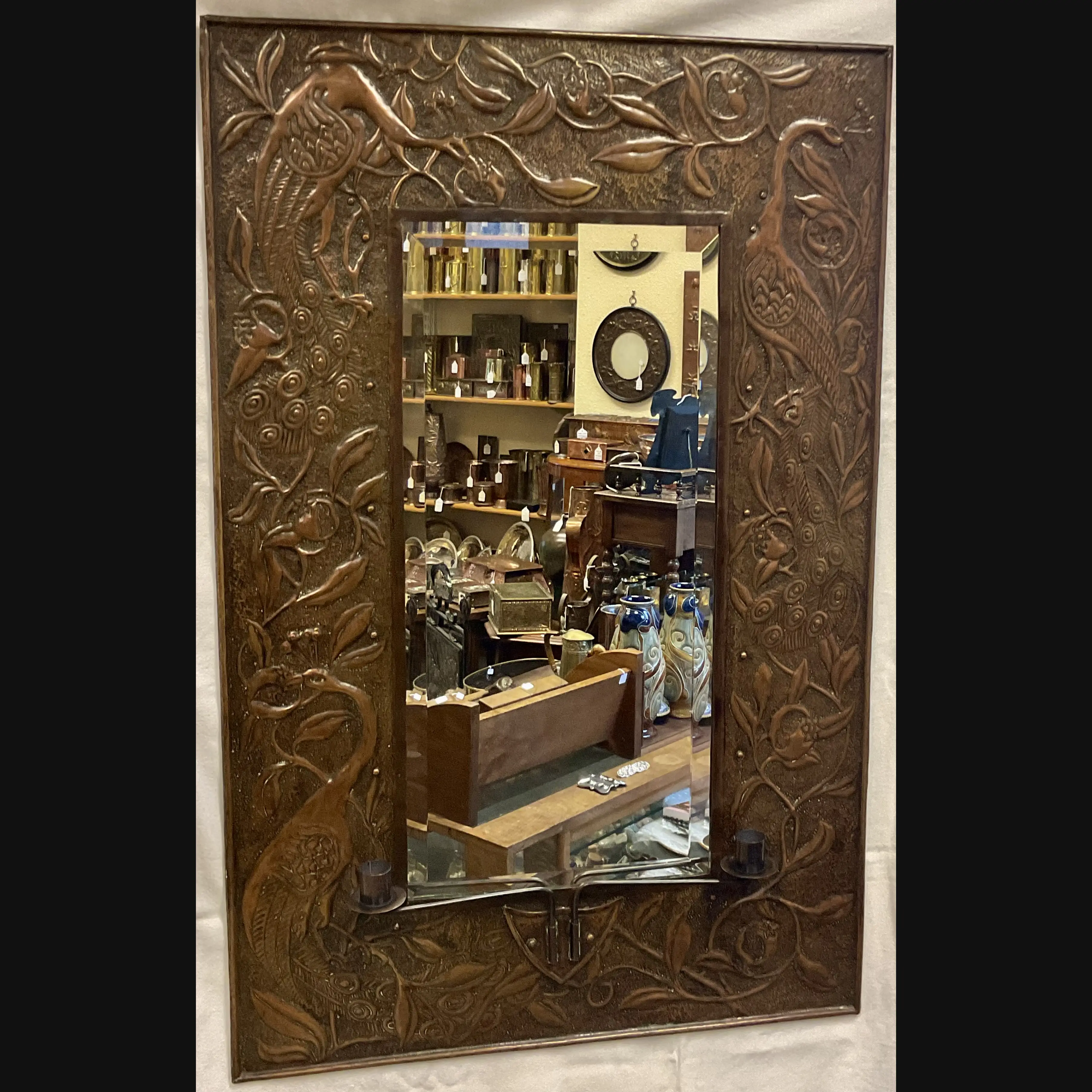 large arts and crafts copper mirror with candle sconces worked with peacocks and pomegranates c1900 10