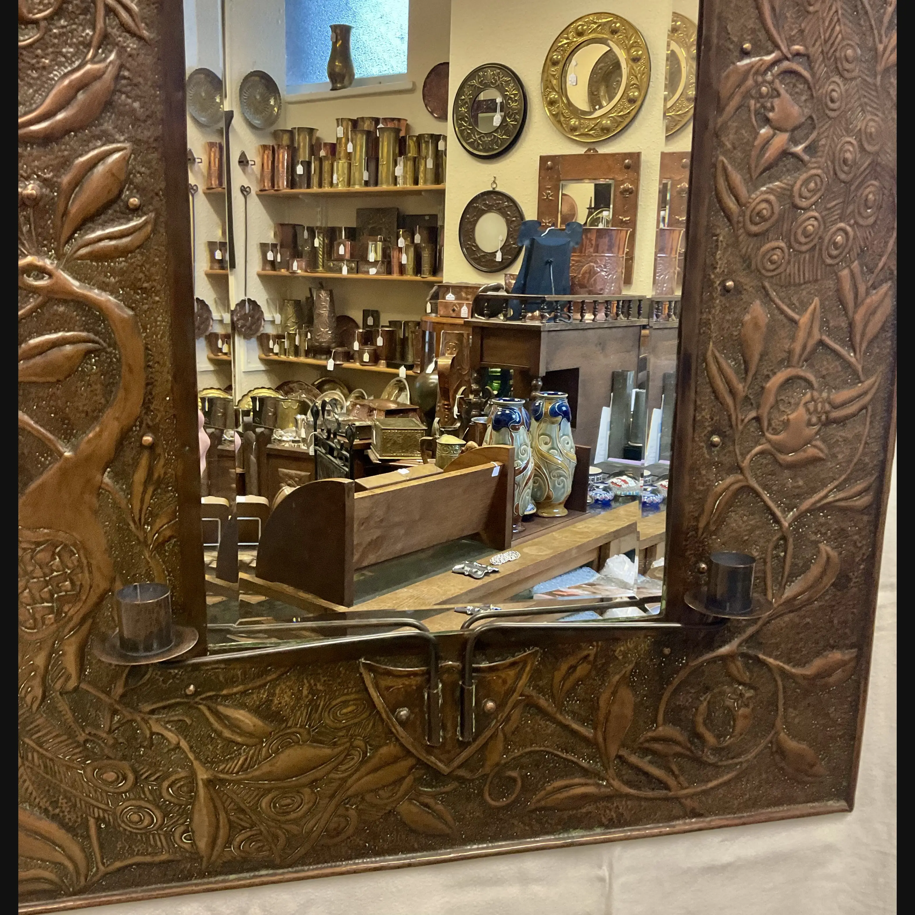 large arts and crafts copper mirror with candle sconces worked with peacocks and pomegranates c1900 10